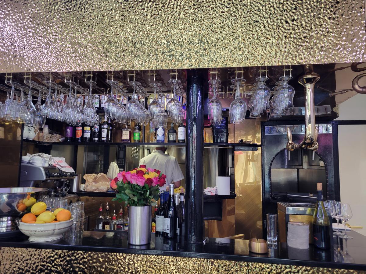 Ambiance du bar Pouët-Pouët avec verres suspendus et bouteilles
