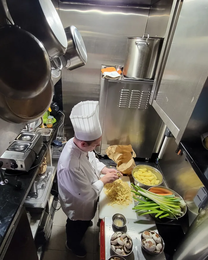 Le chef épluche des pommes de terre dans la cuisine du restaurant Pouët-Pouët