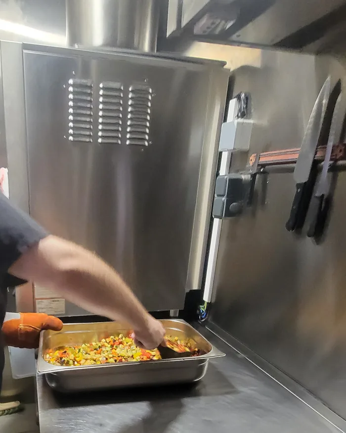 Le chef prépare le plat du jour dans la cuisine du restaurant Pouët-Pouët à Pigalle.